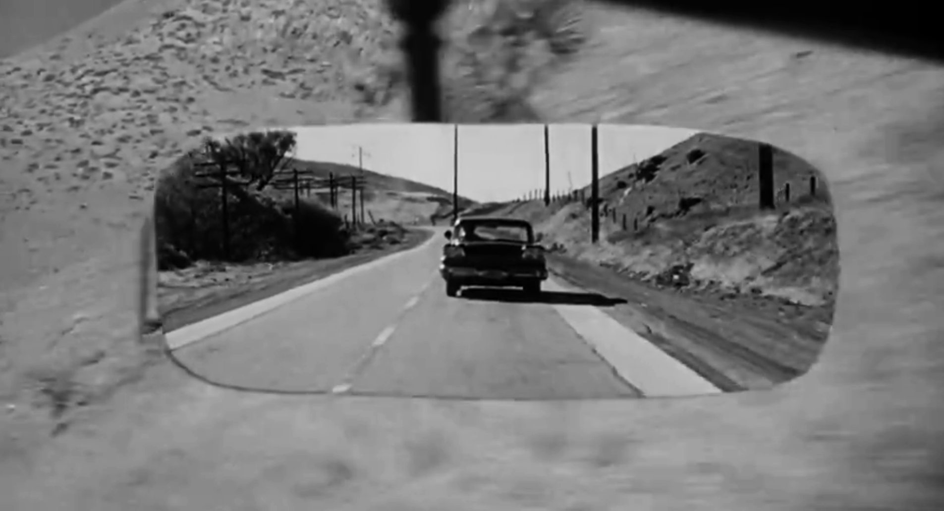 The police car reflected in Marion Crane's rearview mirror.